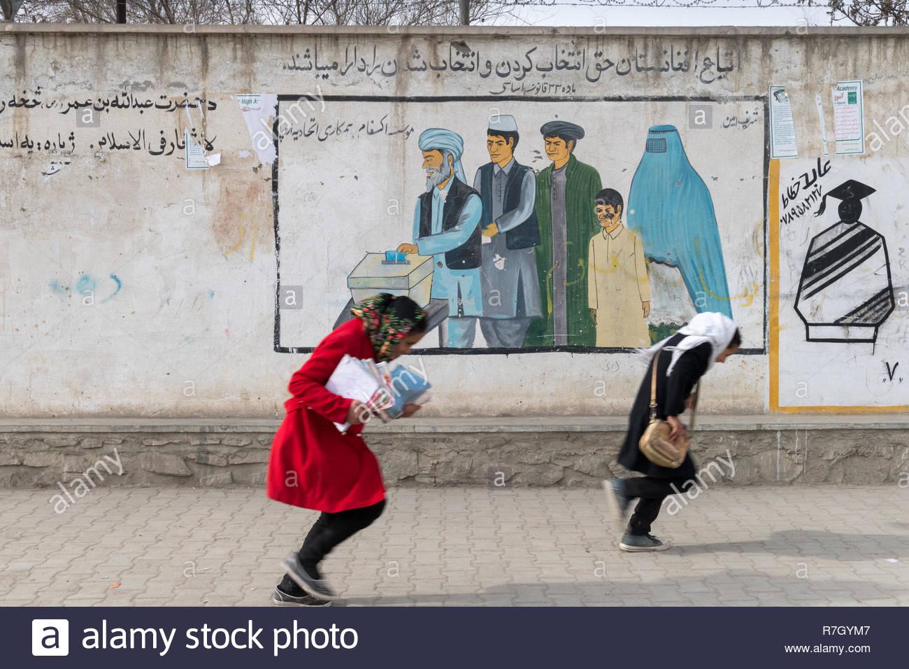 las-ninas-caminando-de-regreso-a-su-casa-despues-de-la-escuela-con-una-pintura-mural-promoviendo-la-votacion-para-hombres-y-mujeres-kabul-provincia-de-kabul-afganistan-r7gym7